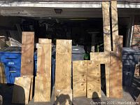 Various sizes of vertical wooden planks lined up next to each other inside garage.