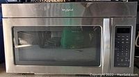Front view of Whirlpool stainless steel microwave showing the door with a window and control panel on the right side.
