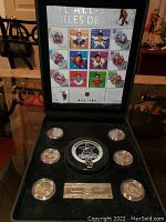 Full view of the 2003 NHL All-Stars commemorative set inside black display case showing stamps on the lid, puck, medallions, and plaque.