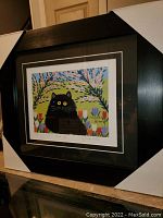 Full front view of framed and matted print showing black cat illustration
