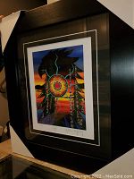 Photograph showing full framed and matted print with protective corner guards, depicting a colorful eagle illustration with a sunset background.