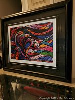 Full view of framed "Salmon Hunter" fine art print showing colorful abstract design and black frame.