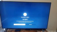 Front view of TV powered on showing “No Signal” screen on HDMI2 labeled PlayStation 4 HDMI2