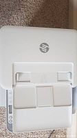 Top view of white HP printer showing paper input tray and HP logo