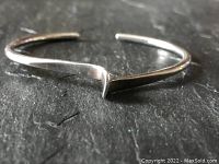 Close-up angled view of the sterling silver cuff bracelet showing the twisted and hammered band and open-ended design.