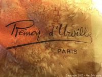Close-up of the signature label on the scarf showing 'Remoy d'Urville Paris' hand signed design.