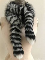 Photo of black and white striped dyed fur scarf wrapped twice around the neck of a dress form, showing fluffy texture and stripe pattern.