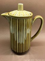 Front side view of mid-century modern ceramic teapot showcasing vertical ridged texture and mustard cream glaze.