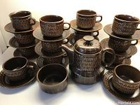 Overview of entire set with stacked cups and saucers, teapot centered, sugar bowl front