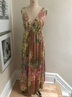 Front full view of the dress on a mannequin showing the full length, floral pattern, and fit.