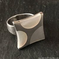 Close-up front angle of the sterling silver ring with abstract mother of pearl inlays showing shape and design.