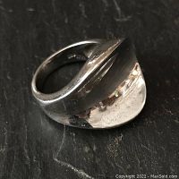 Close-up view of the sterling silver abstract circular ring showing its wrapped circular design and polished finish.