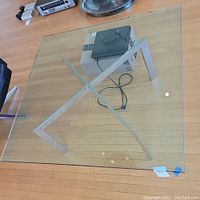 Overhead view of full glass top and chrome X-frame base