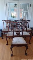 Six dining chairs arranged in room showing overall lot.