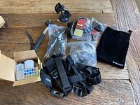 Lot shown with multiple GoPro straps, mounts, LED string lights with remote in box, and a black pouch.