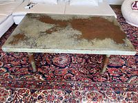 Top and angled views showing the heavily rusted metal table top and sturdy industrial metal pipe base with wheels