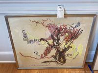 Full view of framed abstract mixed media artwork on beige background with red, yellow, black lines, and organic shapes.