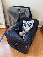 Two black Sherpa pet carriers and a cheetah plush toy shown from front angle