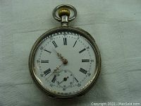 Front view of Minerva pocket watch showing white enamel dial with Roman numerals, seconds subdial, and gold-tone hands.