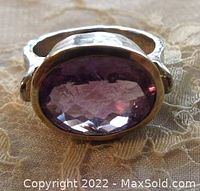 Close-up photo of the oval amethyst stone set in a gold plated edge with hammered silver band showing the stone details and color.