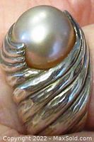 Close-up front view of the ring showing the textured swirl bezel holding the round light pink cultured pearl.