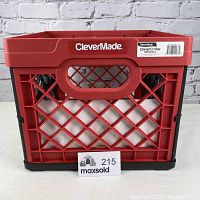 Front view of CleverMade collapsible milk crate in red and black showing built-in handle and lattice sides with brand and product labels.