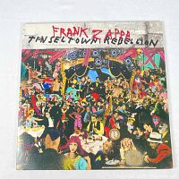 Front cover of the Frank Zappa Tinsel Town Rebellion vinyl LP showing detailed, colorful collage artwork of a lively party scene with many people and performers.