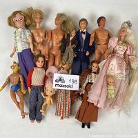 Full view of all 13 assorted vintage dolls including Barbie-like dolls, porcelain dolls, and action figures