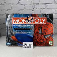 Front view of Spiderman Monopoly Board Game box featuring Spiderman's face and Monopoly logo.