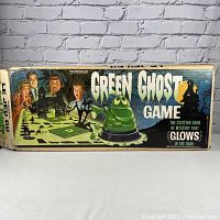 Photo of the vintage Green Ghost game box with artwork of people and green ghost figure on front, showing the box condition.