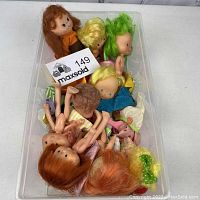Top-down view inside bin showing multiple vintage Strawberry Shortcake dolls with various hair colors and outfits packed together.