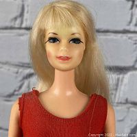 Close-up of doll's face showing blonde hair, blue eyes, and red lipstick.