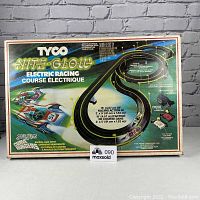 Original boxed packaging showing the TYCO Nite Glow electric racing course and car set with track layout graphic and branding.