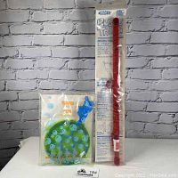 Photo showing sealed Wham-o Bubble Thing bubble maker with red wand and instructions visible inside packaging alongside Avon Tons of Fun bubble maker with round green bubble tray and blue wand, all sealed in original packaging.