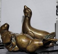 Photo shows two brass bookends shaped as a seal and a walrus with visible patina and wear marks.