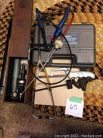 Overview of all items including tools, caring case, and parts on a patterned carpet