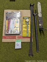 Overview of all tools laid flat: ratcheting die nut & tap wrench in packaging, dial caliper, pickle fork, and large lever tool.