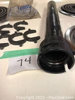 Black cylindrical tie rod end remover tool with multiple plastic clips on white counter next to stove top, Lot number 74 visible.