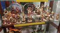 Display shelf with 15 Hummel figurines, featuring children in various poses and clothing.