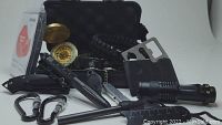 Photo of the opened hard case showing the included survival and safety tools arranged around it.
