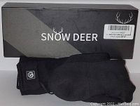 Photo showing Snow Deer branded box with pair of black intelligent heated socks in front.