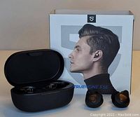 Photo showing Soundpeats Truengine 3 SE wireless earbuds outside and inside charging case alongside packaging box.