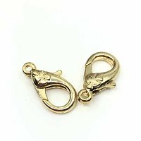 Close up photo of two gold lobster clasps showing the detailed floral engraving on the clasps.