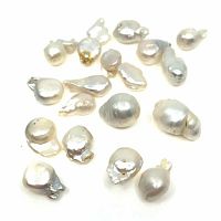 19 white baroque freshwater cultured pearls scattered on white background showing variety of shapes and sizes