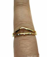 Photo showing the two gold plated stacking rings worn on finger: one V-shaped plain band and one band with small cubic zirconia stones spaced evenly around it.