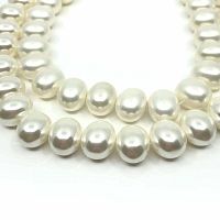 Close-up image of oval giant clam shell beads showing smooth, lustrous surface and shape.