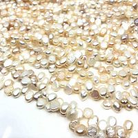 Close-up of multiple tri-colour freshwater cultured pearls showing potato shapes and natural luster.