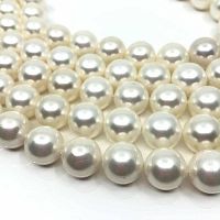 Close-up of round shell pearl beads showing their smooth, shiny surface and creamy white color.