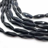 Close-up of faceted black onyx olive-shaped beads on strand to show bead shape and finish