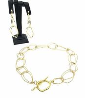 Full view of necklace laid out flat and matching earrings displayed on black stand showing shape and size